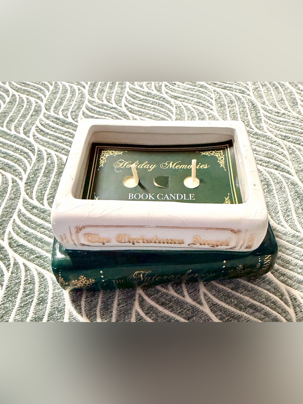 Holiday Book Candle featuring a stack of ceramic books with a soy candle on top